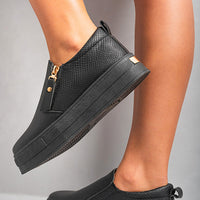 Black textured slip-on trainers with side zipper detail and dark elastic gore