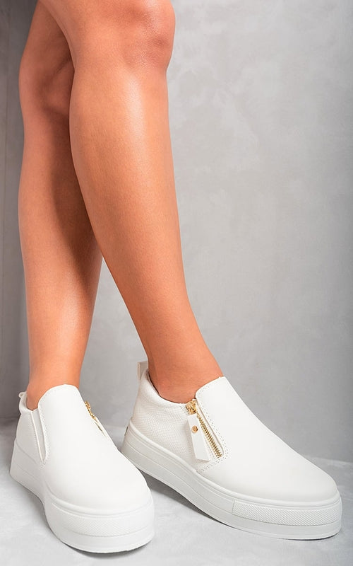 White slip-on trainers with side zipper detail and gold-tone accents, low platform sole