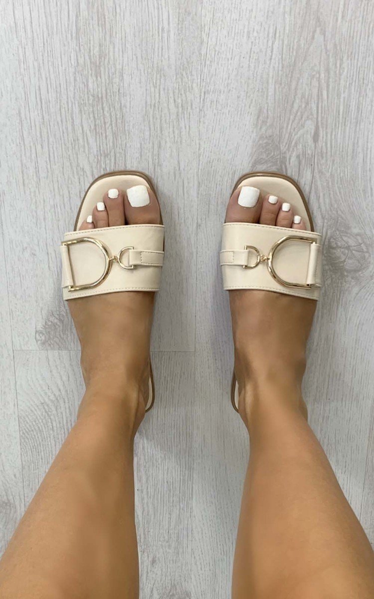 Beige open-toe slide sandals with wide strap and gold tone ring detail