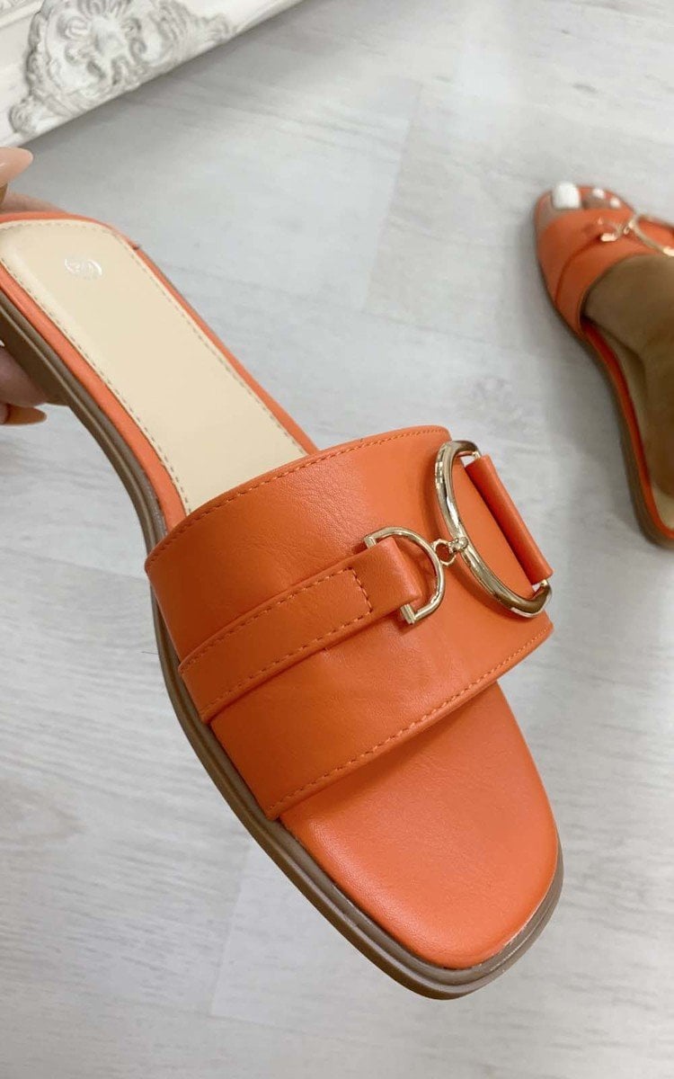 Orange slide sandals with wide straps and gold tone ring buckle detail