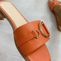Orange slide sandals with wide straps and gold tone ring buckle detail