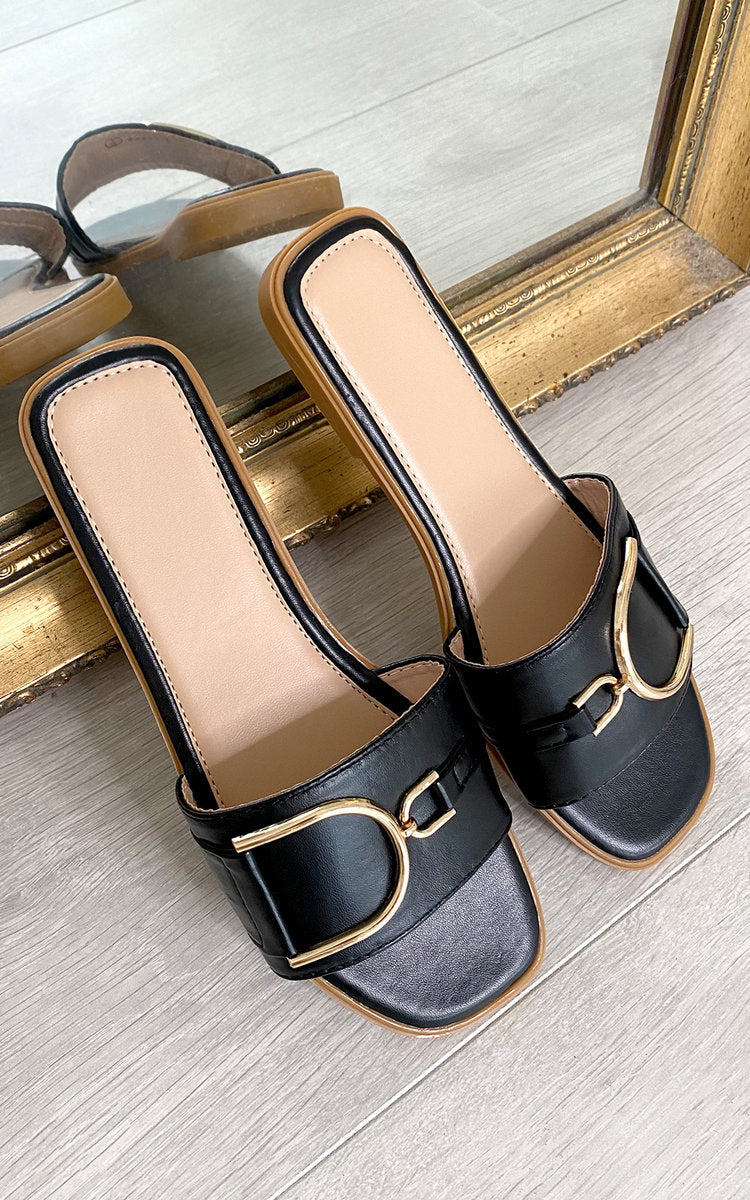 Black slide sandals with wide straps and gold-tone ring buckle detail