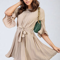Beige pleated mini dress with tie waist, wide sleeves, and short gathered skirt.