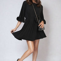 Black pleated mini dress with tie waist and wide three-quarter sleeves