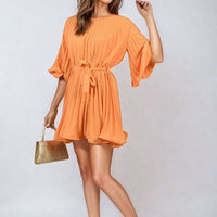 Orange pleated mini dress with tie waist and wide sleeves, short gathered skirt.