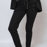 Black drawstring tapered trousers with side pockets, front close-up