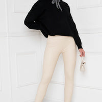 Black faux leather leggings with slim fit and ankle-length cuffs.