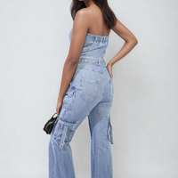 Blue denim strapless cargo jumpsuit with belt, flap pockets, and strapless neckline
