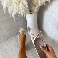 Beige ballet flats with bow and pearl bead trim, round toe, low heel