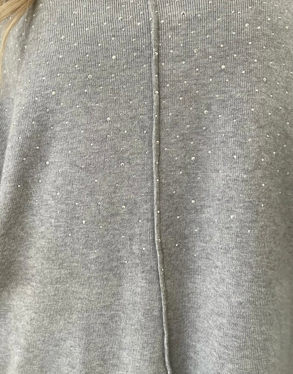 Close-up of grey knitted fabric with rhinestone speckle detail