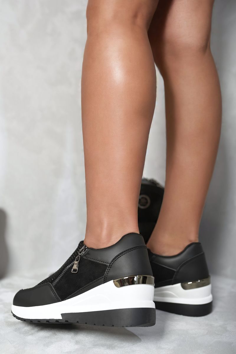 Black platform sneakers with side zip, gold accent trim, and white sole