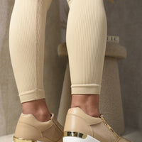 Beige platform trainers with gold heel detail and cushioned sole