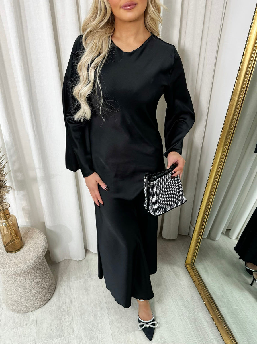 Black round-neck maxi dress with long flared sleeves, side view