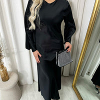 Black round-neck maxi dress with long flared sleeves, side view