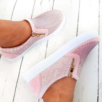 Pink slip-on trainer worn, diamante front with gold zip pull and croc-effect sides.