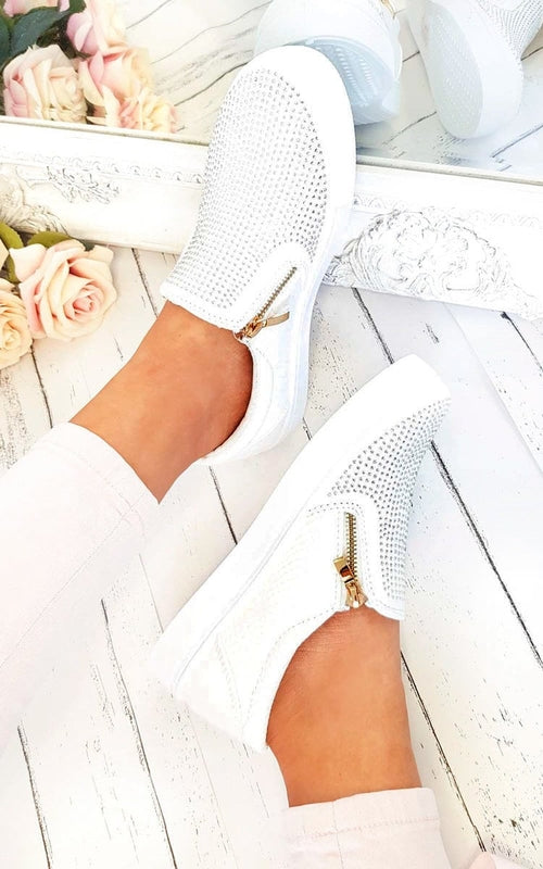 White slip-on trainer worn, diamante side panels and gold zip detail.