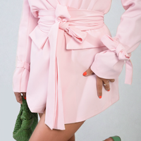 Pink belted blazer jacket close-up with bow waist tie and V-neckline