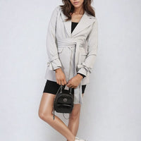 Pale grey collared blazer jacket with V-neck, long sleeves, and waist belt tie