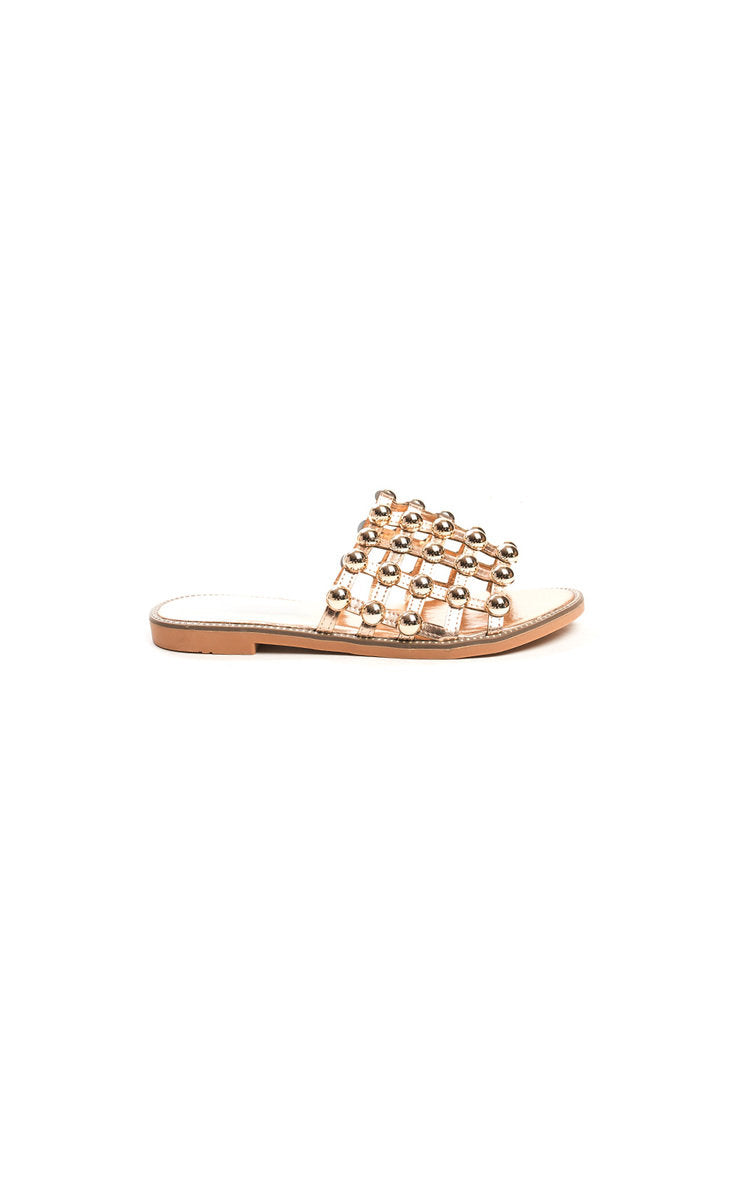 Nude flat slide sandals with studded lattice strap and rhinestone studs, front view