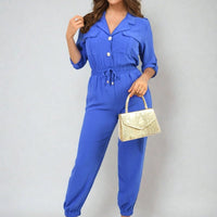 Royal blue collar button-front jogger jumpsuit with drawstring waist and cuffed legs.