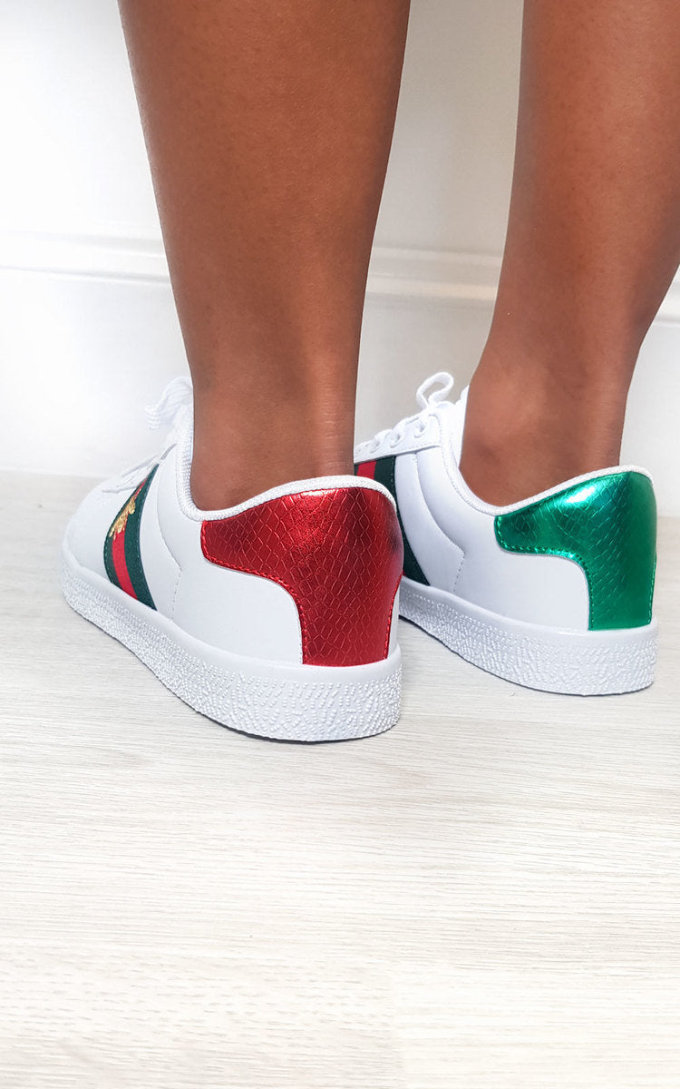 White trainers showing red and green heel panels, low-top lace-up design
