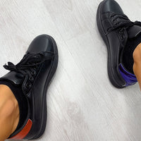 Pair of black lace-up trainers with orange side stripe and textured sole