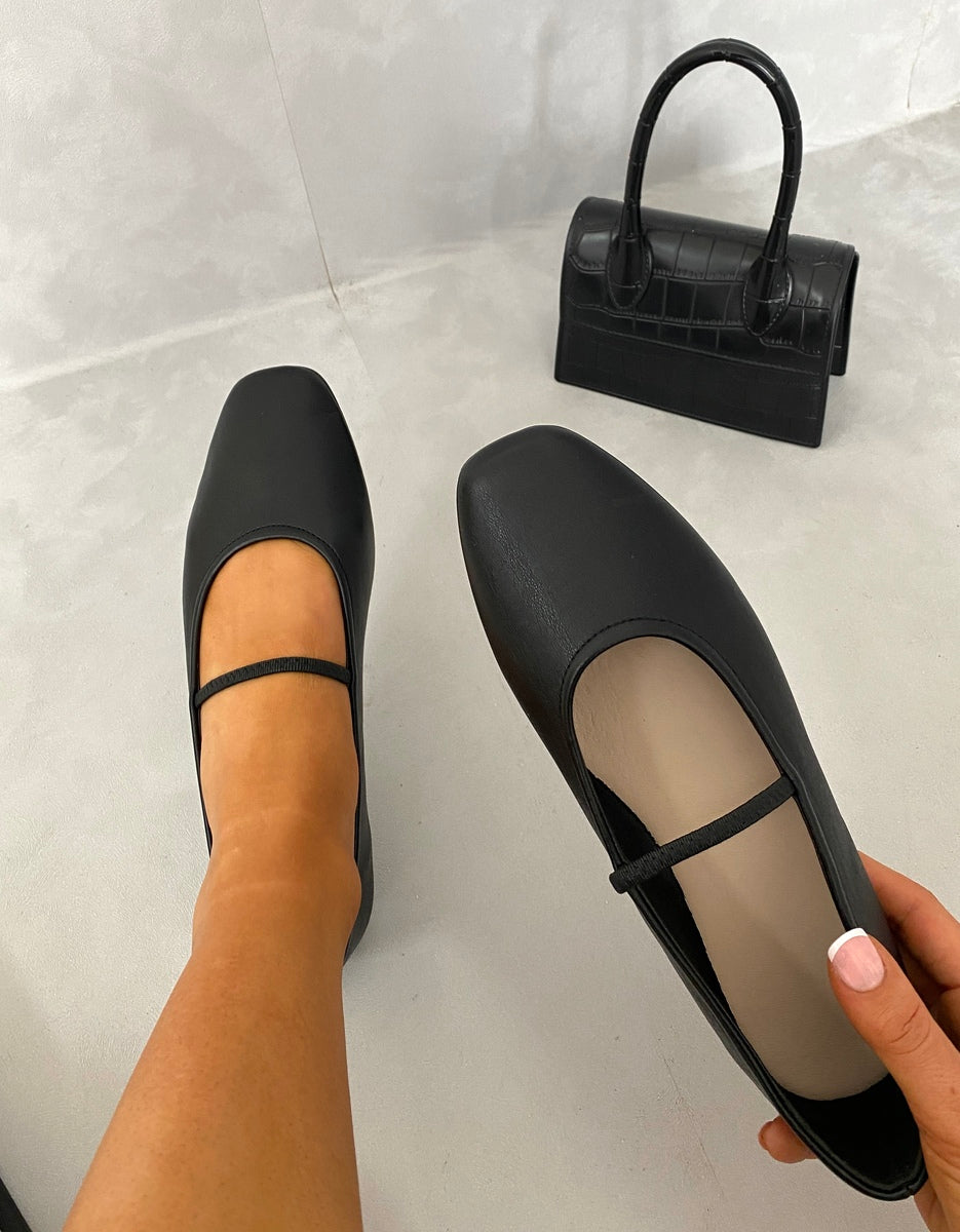 Black round-toe ballet slip-on flats with thin ankle strap, side view