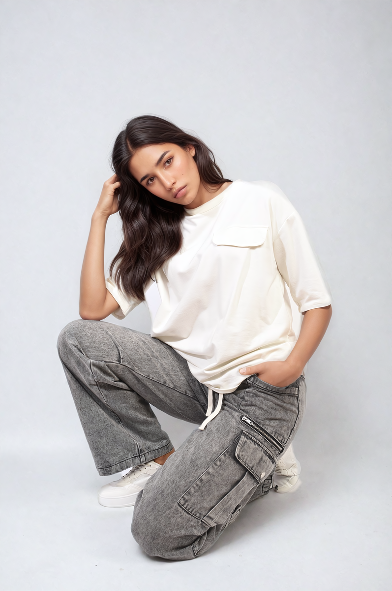 Grey cargo jeans with drawstring waist, multiple pocket panels, relaxed kneeling pose