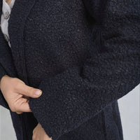 Navy textured button-up jacket detail with front pocket flap and button