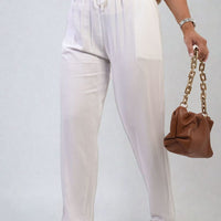 White high-waist drawstring trousers with side pockets, gathered elastic waist detail