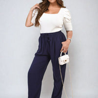 Navy high-waist drawstring trousers with side pockets and loose flowing fit