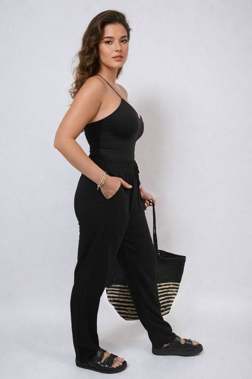 Black high-waist drawstring trousers with side pockets and relaxed wide-leg drape