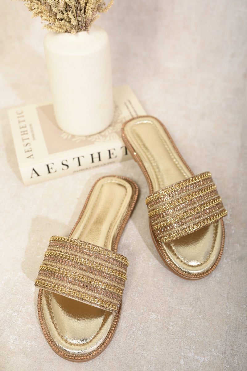 Gold embellished flat slide sandals with wide straps and metallic footbed