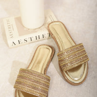 Gold embellished flat slide sandals with wide straps and metallic footbed