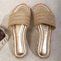 Gold-tone slide sandals with wide embellished straps and glossy metallic footbed