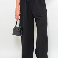 Black wide-leg trousers with gathered drawstring waist, front view