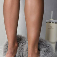 Grey faux fur open-back slippers with low-profile sole, worn by a model