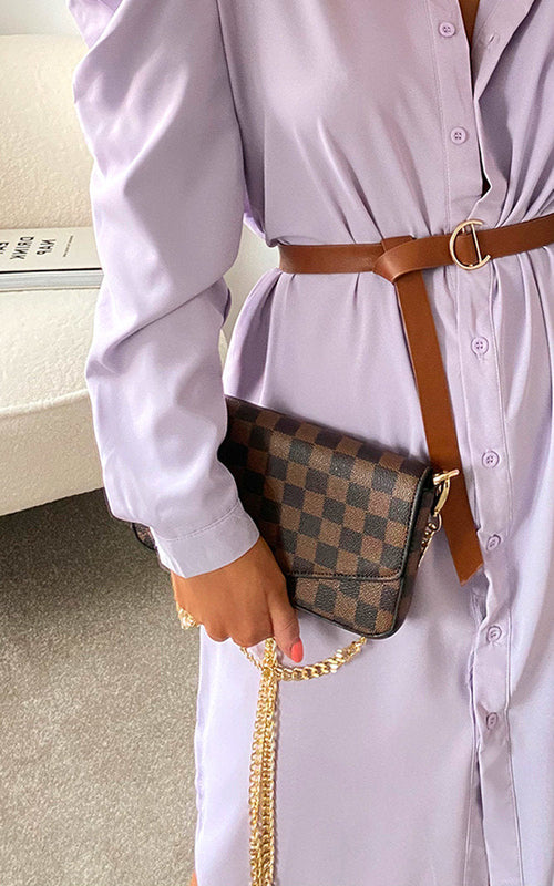 Brown check clutch bag with front flap and gold chain strap, carried over shoulder