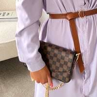Brown check clutch bag with front flap and gold chain strap, carried over shoulder