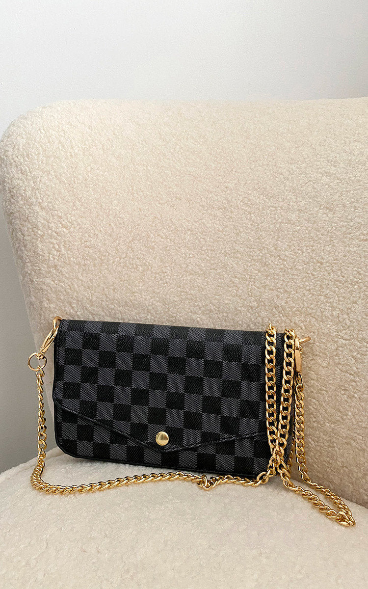 Black check clutch bag with front flap, gold chain strap and magnetic snap