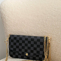 Black check clutch bag with front flap, gold chain strap and magnetic snap