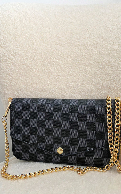 Black check clutch bag with front flap and gold chain shoulder strap