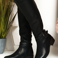 Black knee-high boots with buckle strap detail and stacked low heel