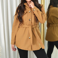 Camel belted jacket with gold buttons, collar, and flap pockets on long sleeves.