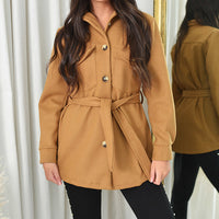 Tan belted jacket with button placket, tie waist belt, and flap pockets.