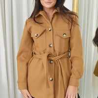 Camel tan belted jacket with snap-button front, flap pockets, and long sleeves.