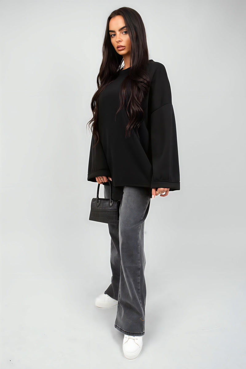 Oversized black sweatshirt with round neck and long sleeves, relaxed fit on model.
