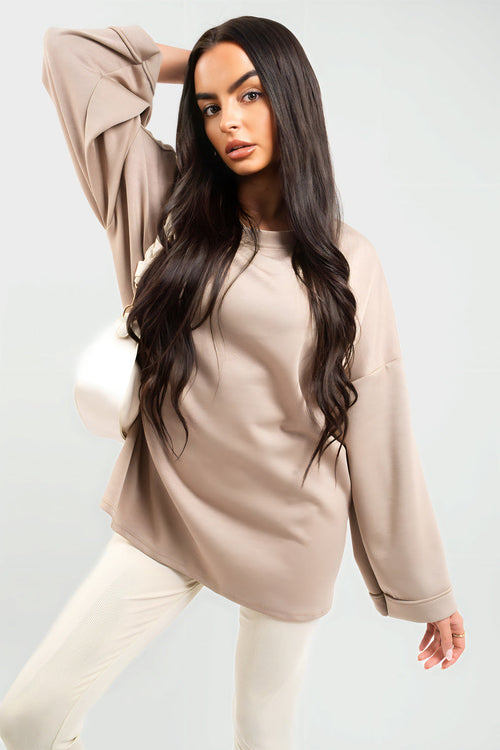 Oversized beige sweatshirt with round neck and long sleeves, relaxed drape.