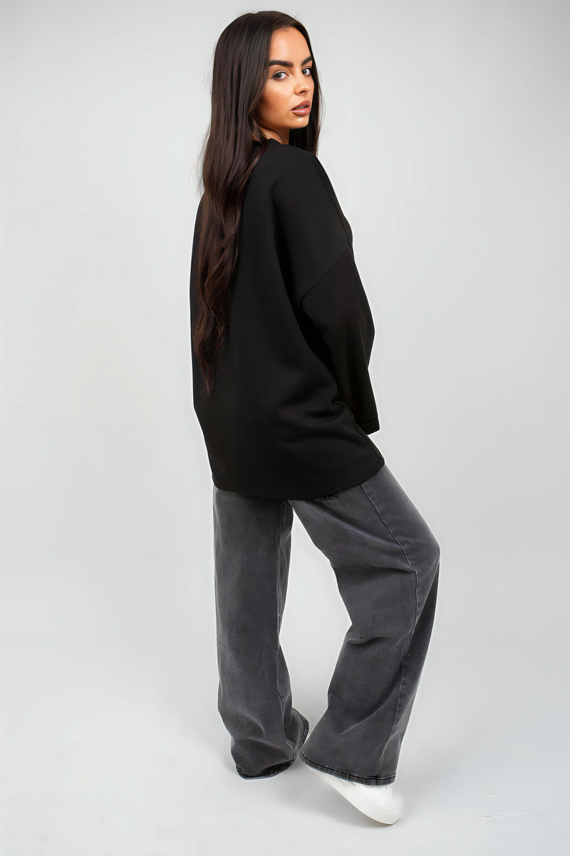 Oversized black sweatshirt with round neck and long sleeves, side profile.