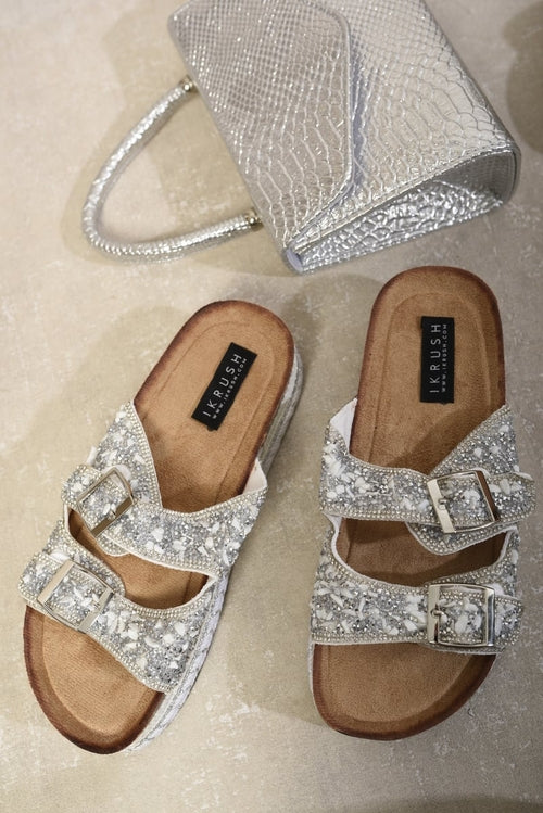 Sparkly silver double-buckle platform sandals with tan footbeds, pair view